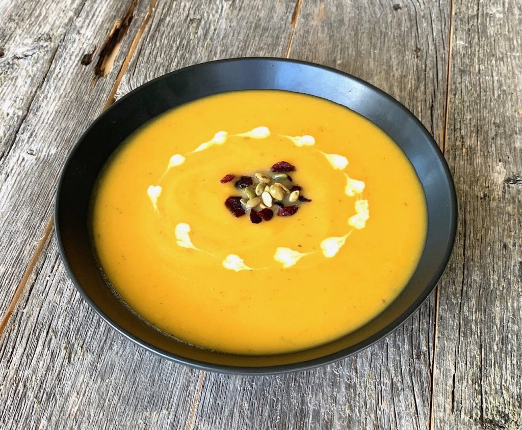 bowl of butter nut squash soup with garnishes