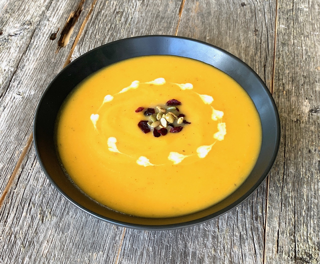 bowl of butter nut squash soup with garnishes