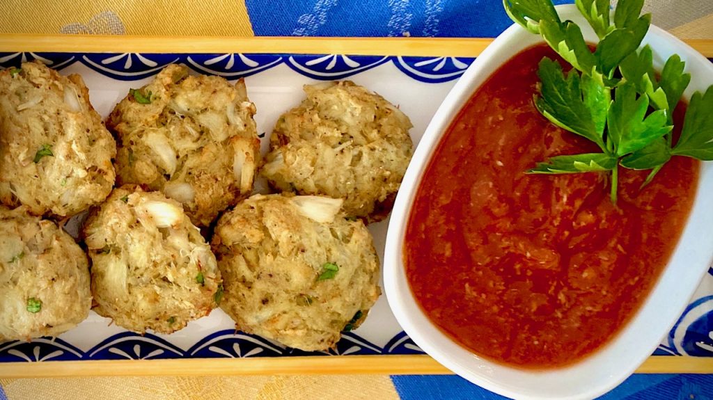 Perfect Baked Crab Cake Bites with Spicy Cocktail Sauce on a plate