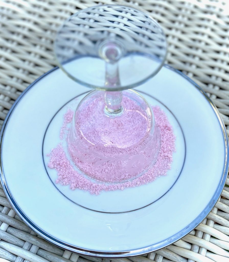 Sugaring the rim of a glass with pink sugar