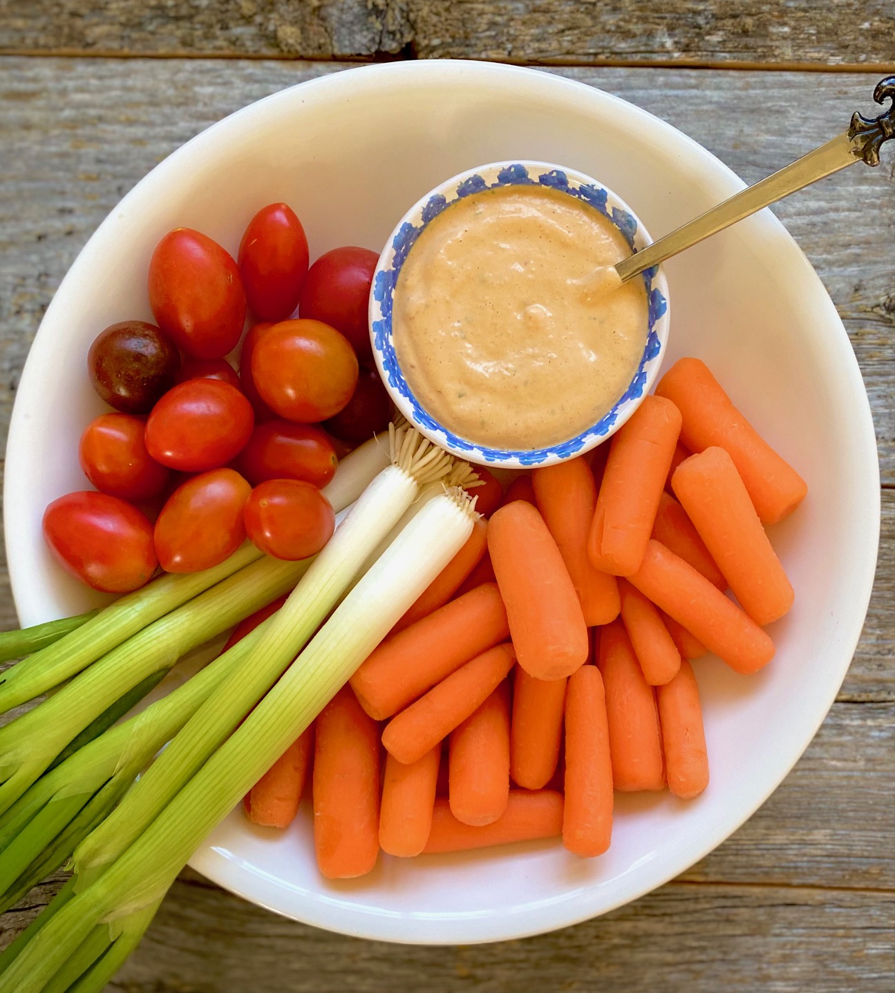 carrots, tomato and scallions in white bowl with cup of southwest ranch dressing