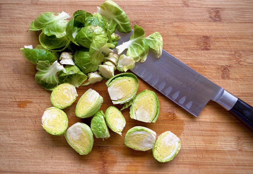 trimming brussel sprouts with a knife on cutting board