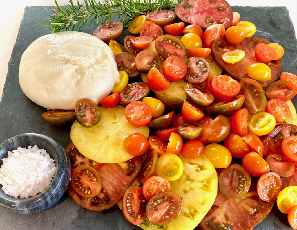 a plate of heirlooms with cheese and rosemary
