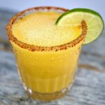 1 mango margarita with a lime and chiili on rim