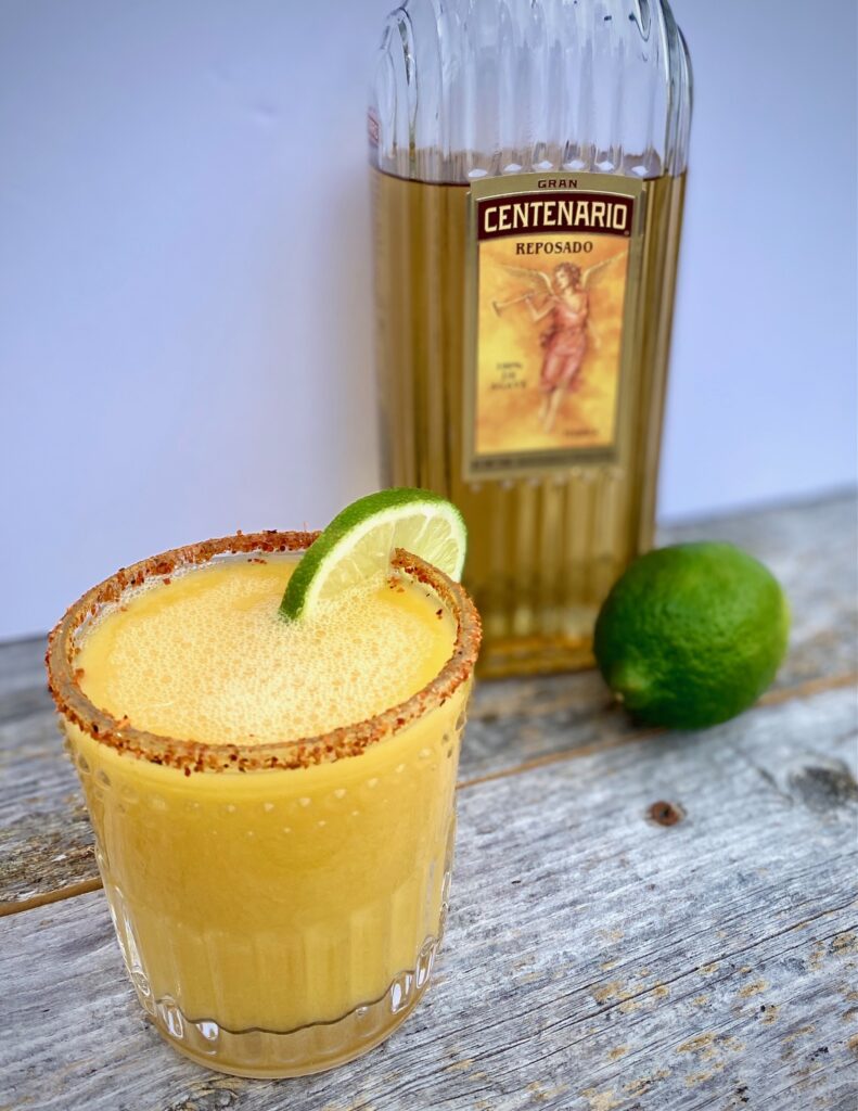 1 Spicy Mango Margarita with a lime and bottle of tequila