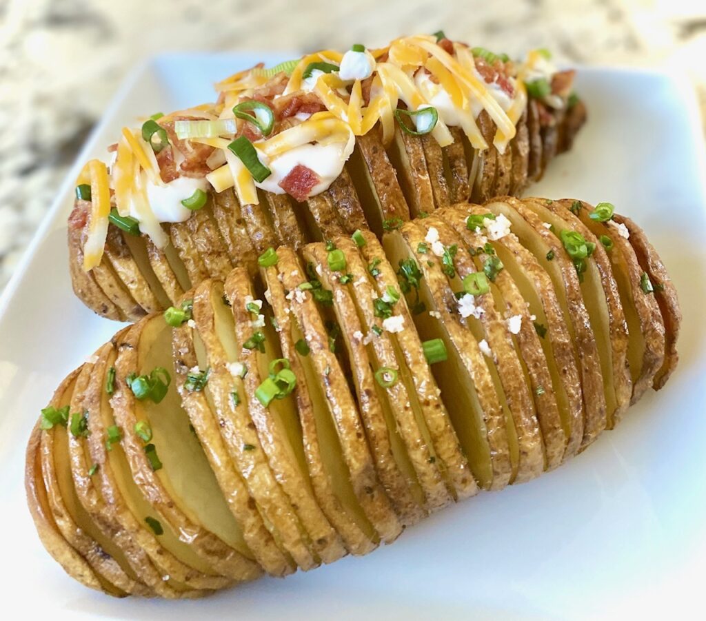 two Hasselback potatoes with toppings