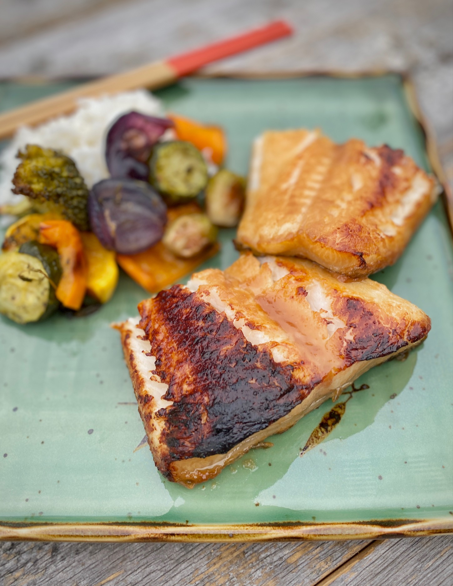 miso glazed sea bass on green plate with vegetables