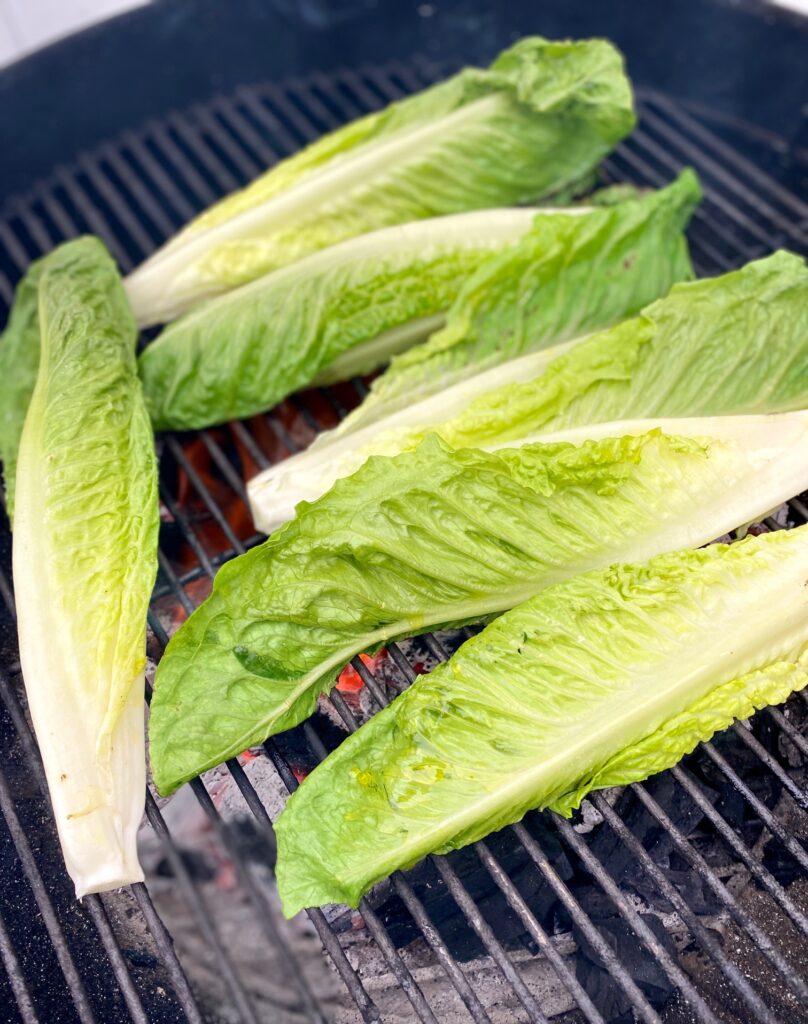 grilling lettuce heads on a charcoal grill