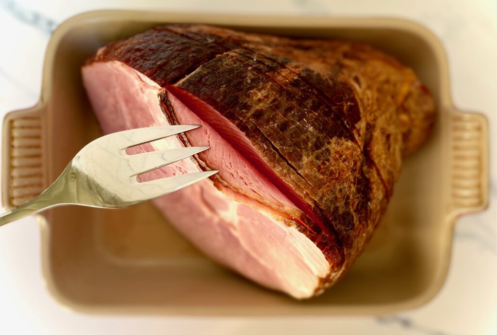 Ham fanned out in a pan with a fork