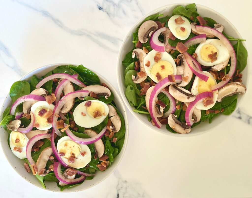 2 bowls of salad with spinach, mushroom, egg and onion