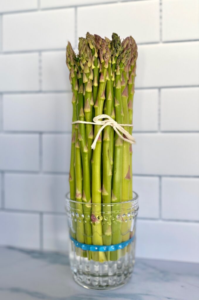 asparagus standing up in a jar with water