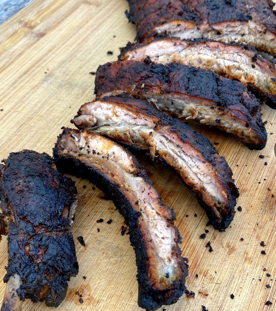 a cutting board of cooked and rubbed ribs