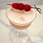 a drink overhead with foam and raspberries
