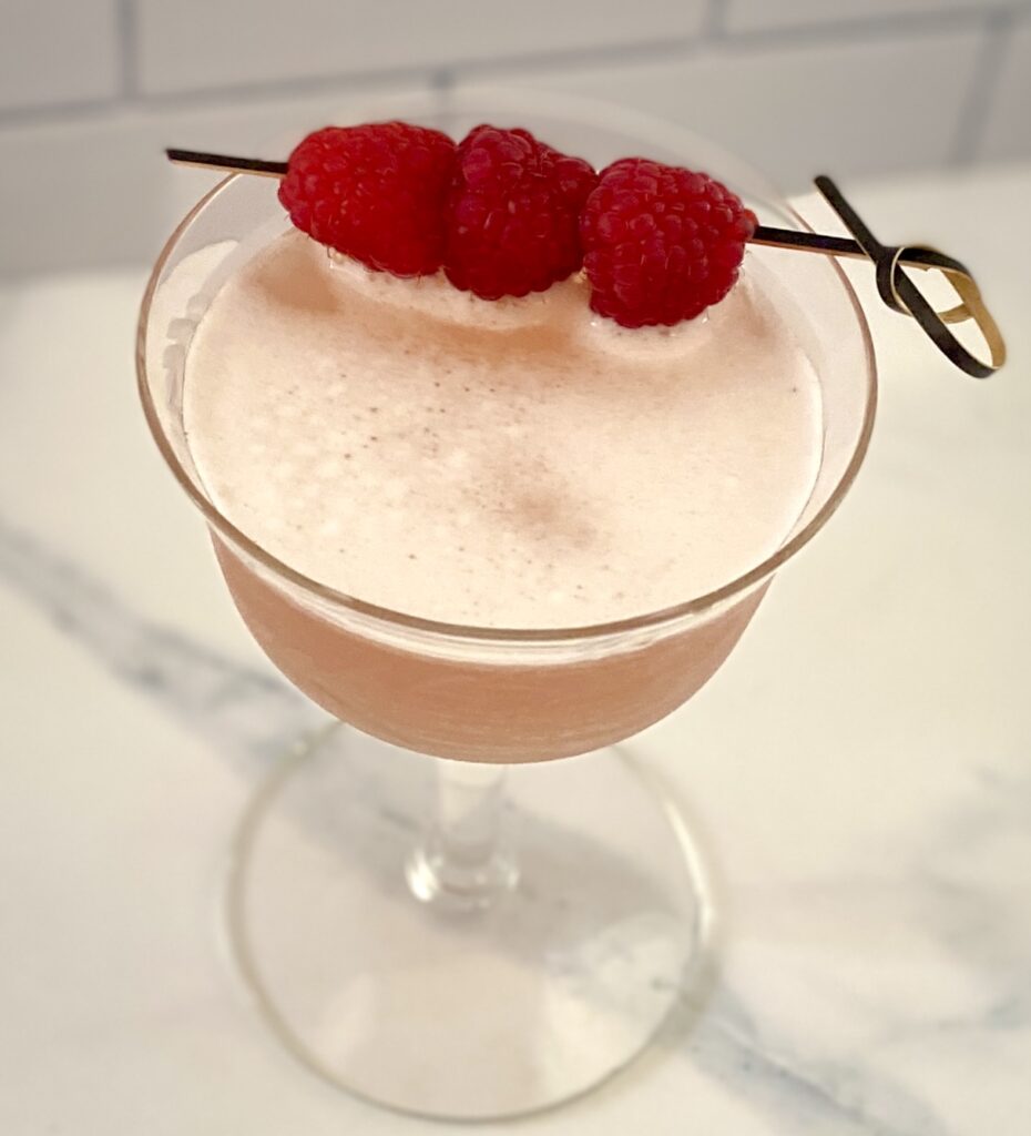 a drink overhead with foam and raspberries