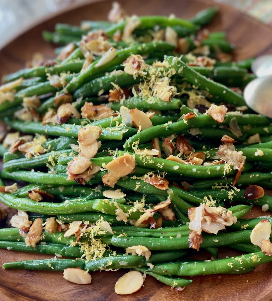 close up of green beans on a wood plate