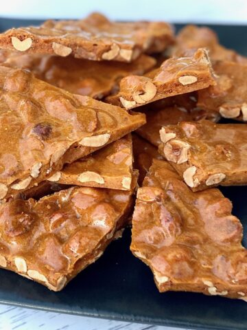 Peanut brittle pieces on black plate