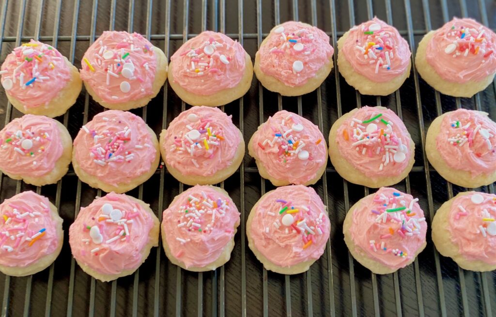 a rack of pink frosted sugar cookies