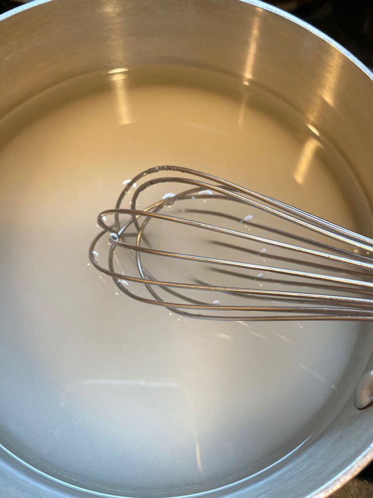 pan of sugar water with whisk