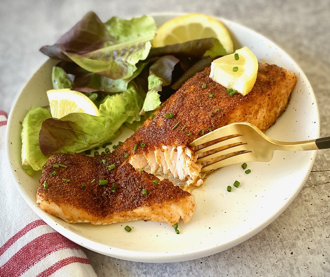 a piece of seasoned salmon + lettuce on a plate