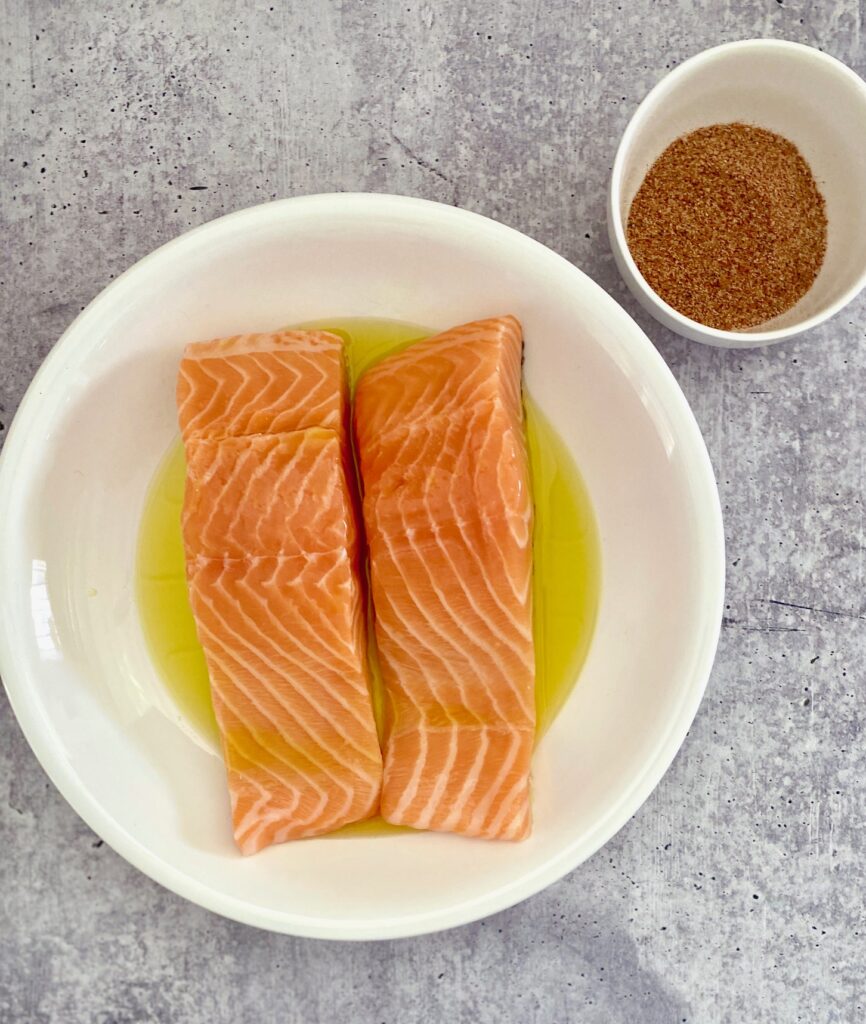 2 pieces of salmon in a bowl of olive oil