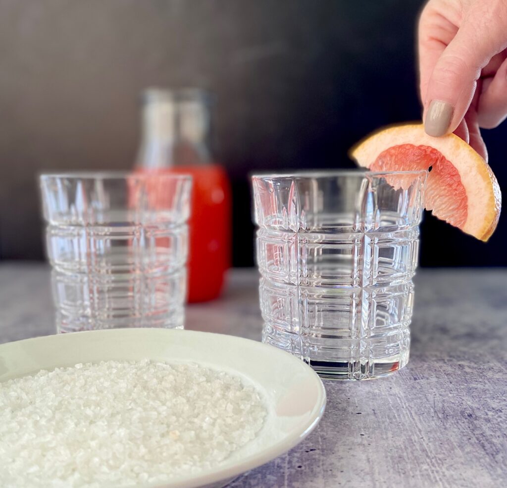 rubbing cut fruit on a rim of a glass