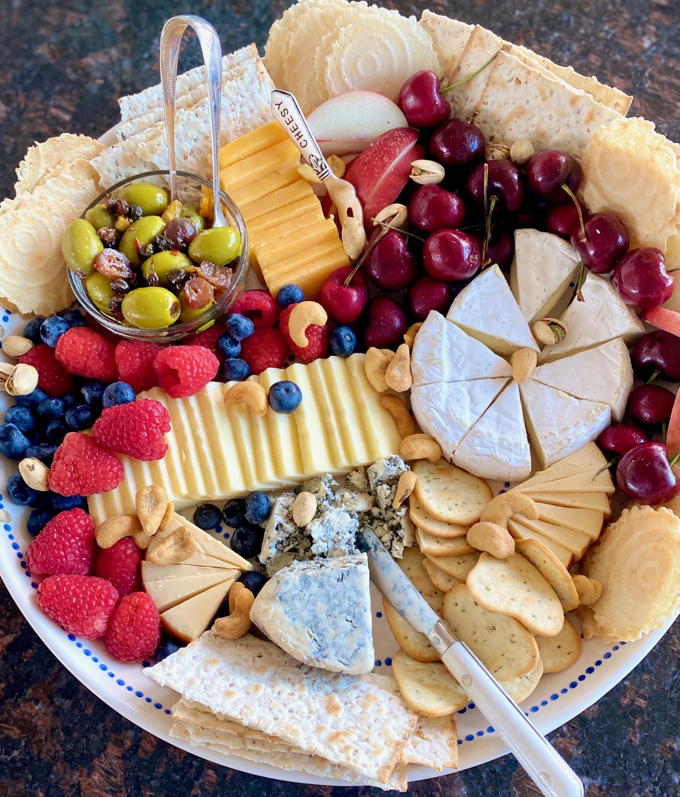 tray with a variety of cheese, crackers, nuts and fruit