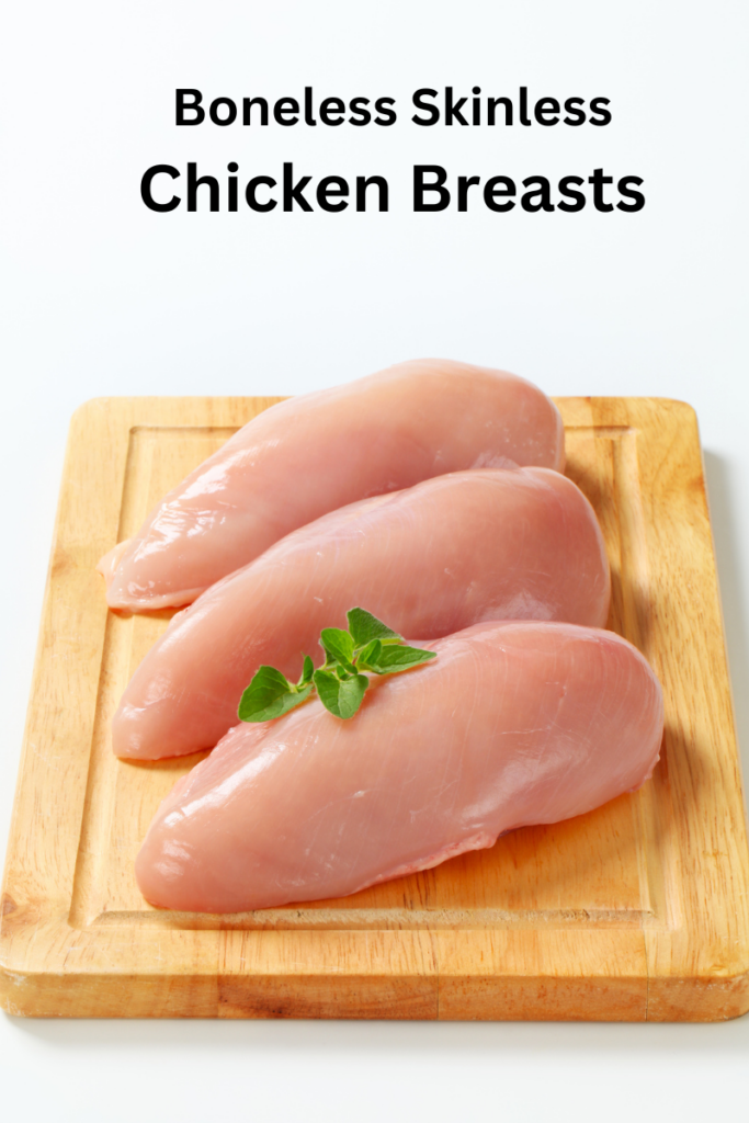 Skinless, boneless chicken breasts on wooden cutting board