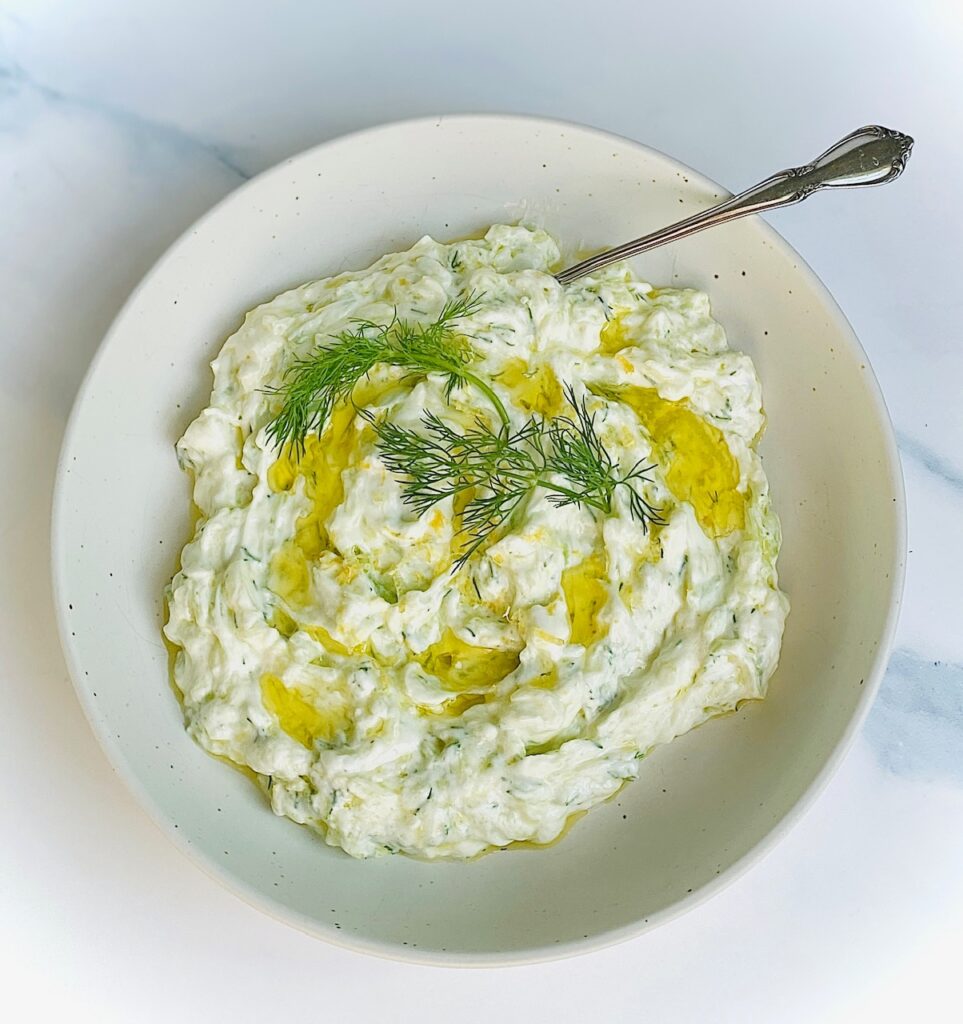 Tzatziki sauce in a white bowl with a spoon