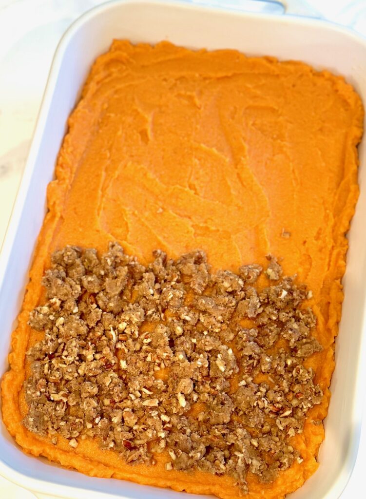 Adding topping to pan of sweet potatoes