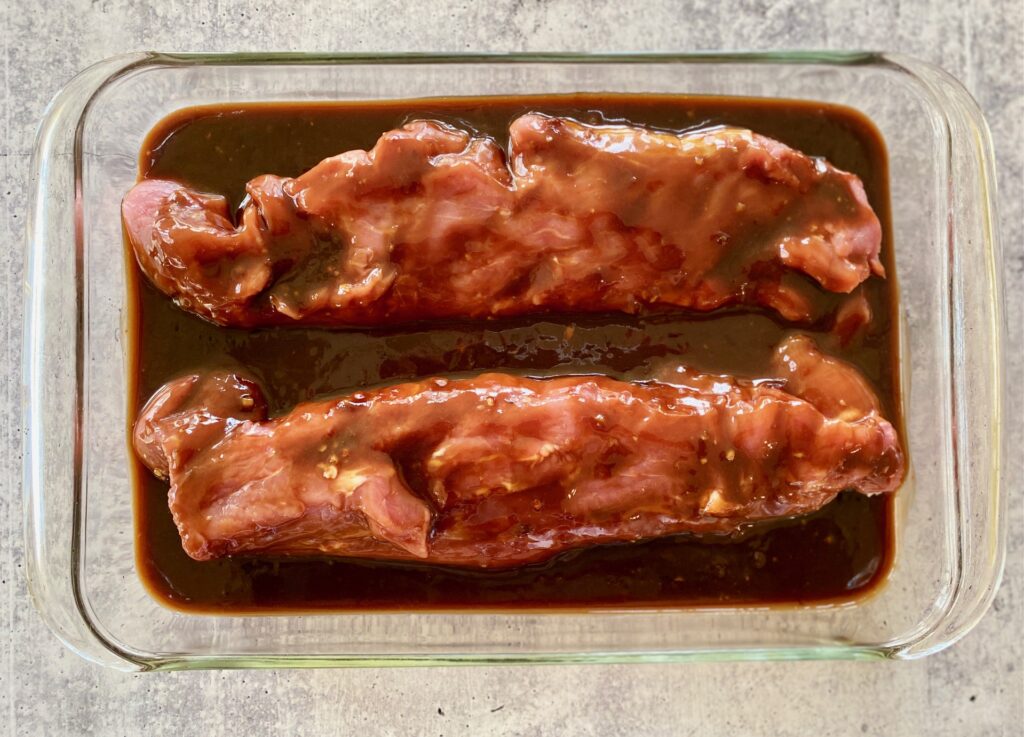 2 marinating asian pork tenderloins in glass pan