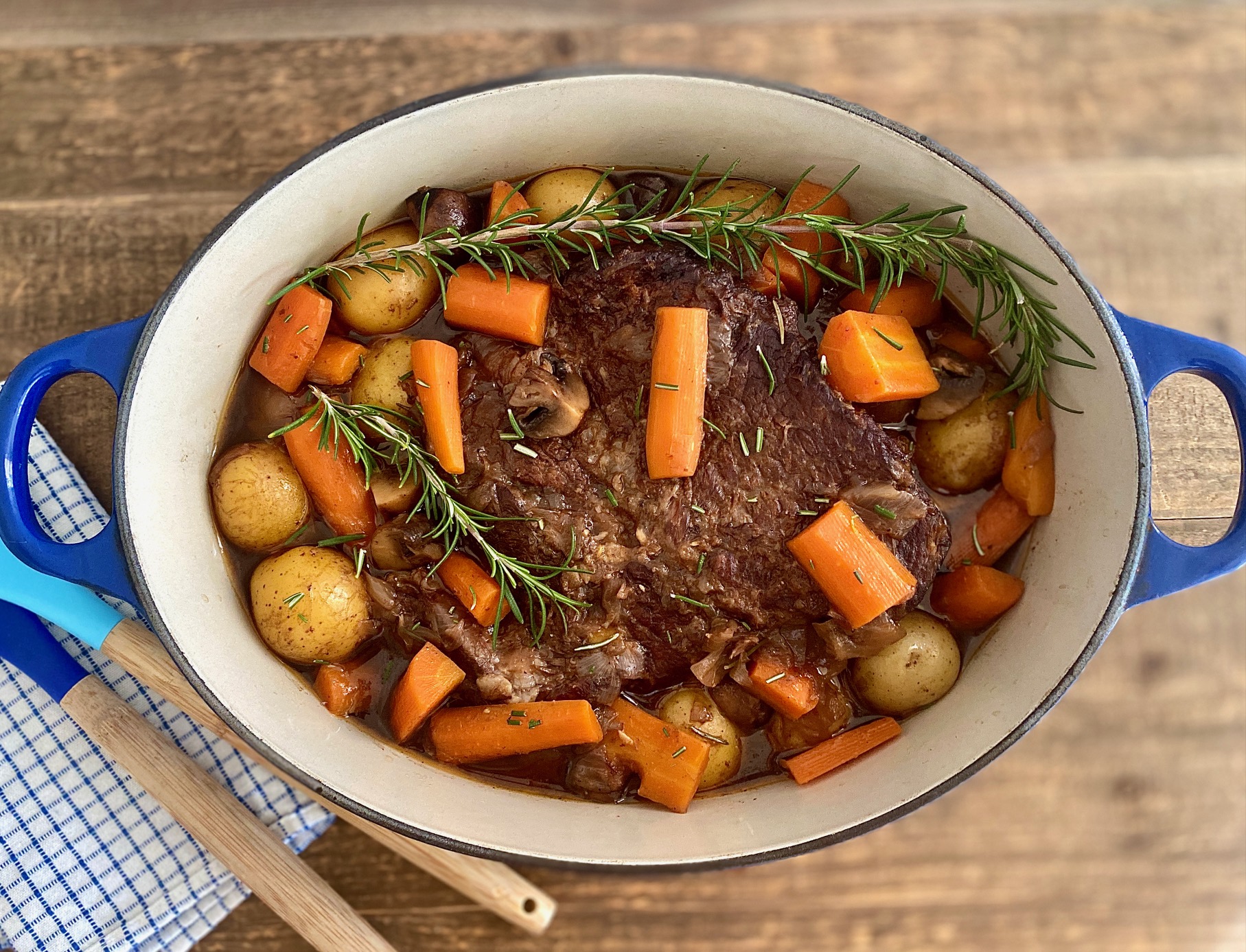 dutch oven with a cooked pot roast and vegetables