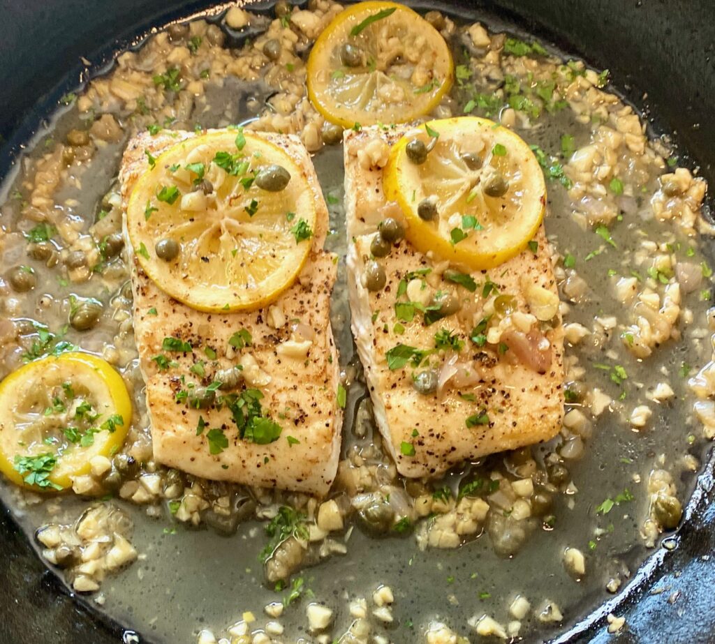 2 Halibut fillets in pan with lemons and capers