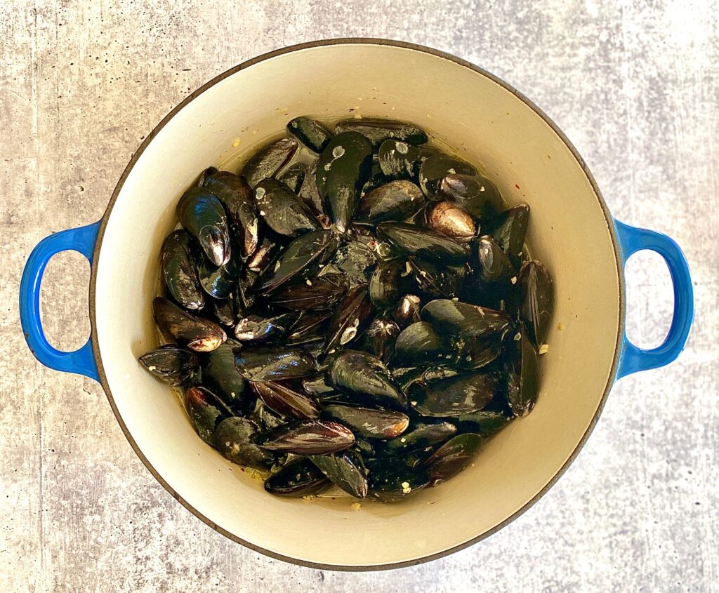 dutch oven with mussels in aromatics