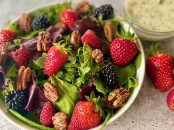bowl of berry salad with bowl of dressing