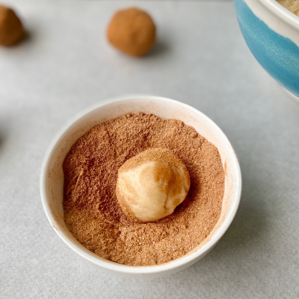 cookie ball in cinnamon sugar mix