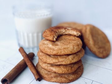 stack of snickerdoodle with bite missing and milk glass