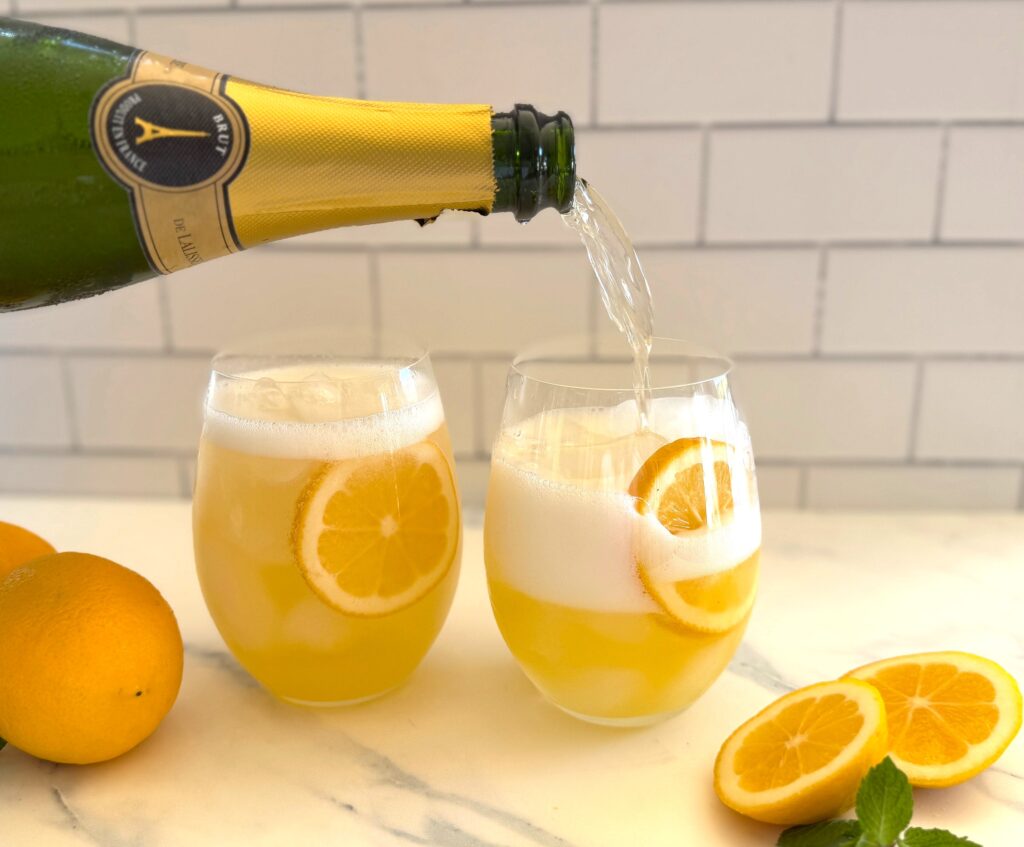 Pouring sparking wine into Limoncello Spritz Cocktail