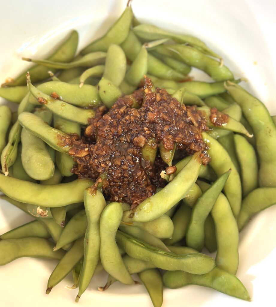 Pour garlic sauce on Edamame