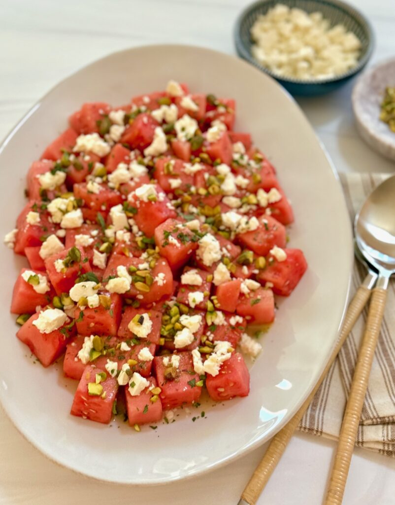 large platter of watermelon salad with mint, feta and nuts