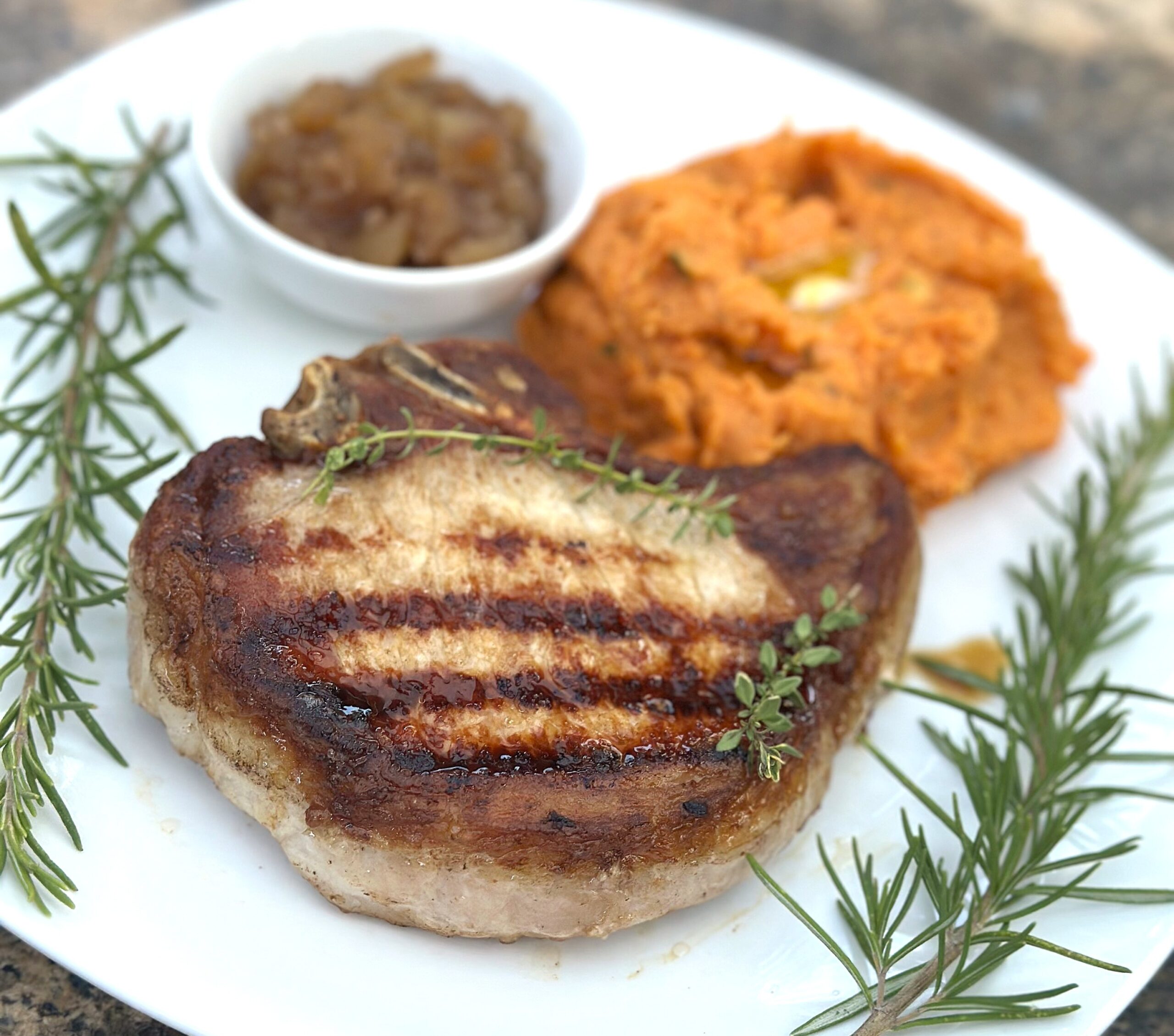 pork chop, chutney in a bowl and mashed sweet potatoes