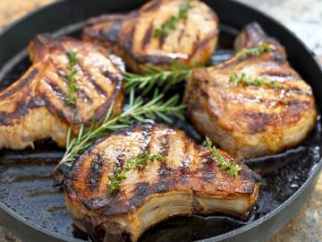 4 pork chops in a black pan