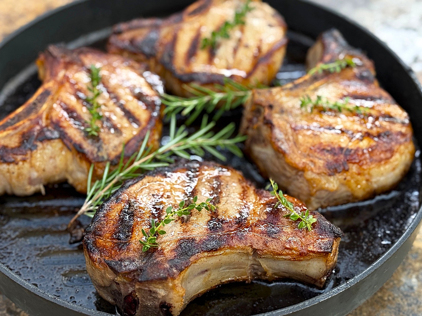 4 pork chops in a black pan