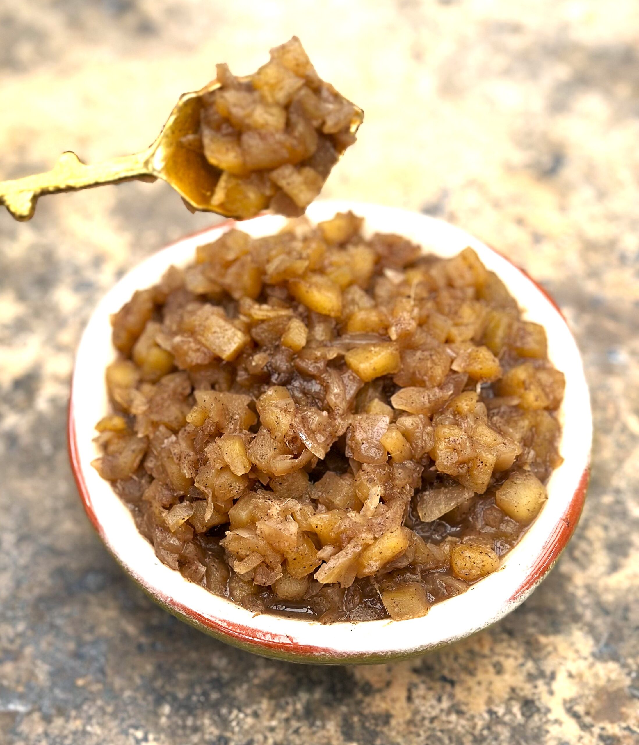 A bowl of chutney and a spoon