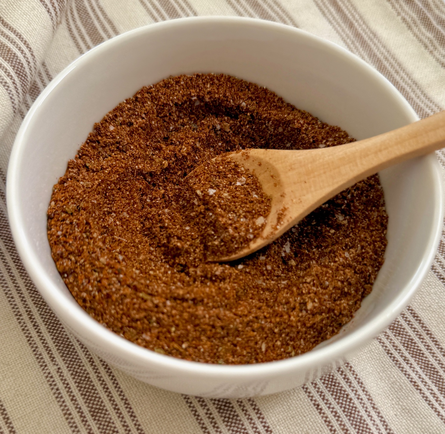 mixed Chili seasoning in a bowl with a wooden spoon
