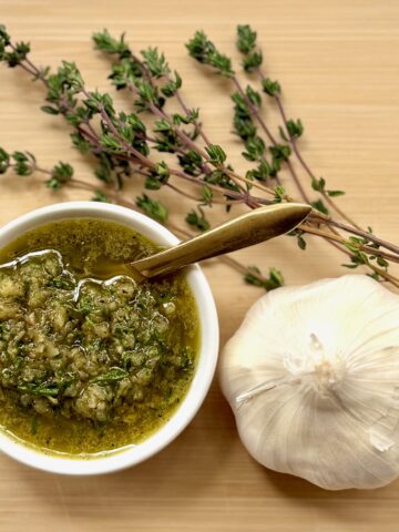 beef rub seasoning, bulb of garlic, and sprigs of fresh thyme