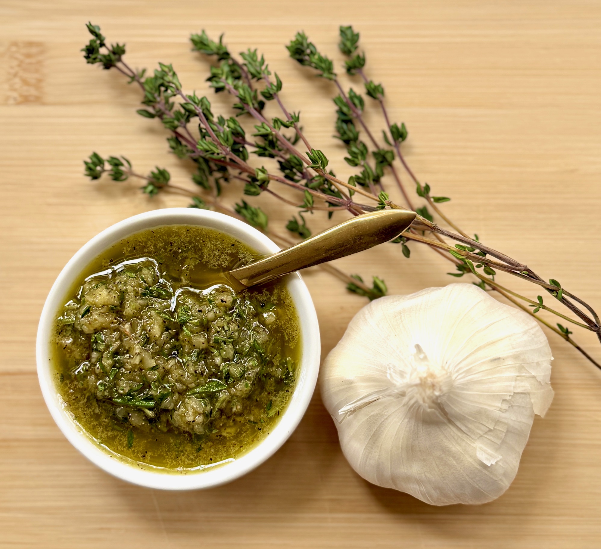beef rub seasoning, bulb of garlic, and sprigs of fresh thyme