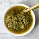 beef rub paste in white bowl with a gold spoon