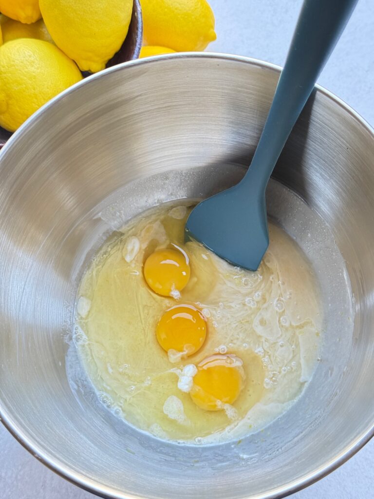 batter with eggs in silver bowl and blue spoon