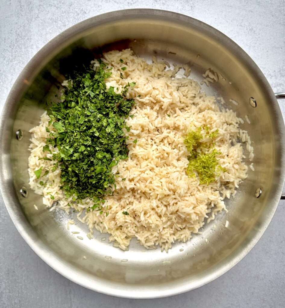 cooked rice with cilantro, lime and zest in a pan