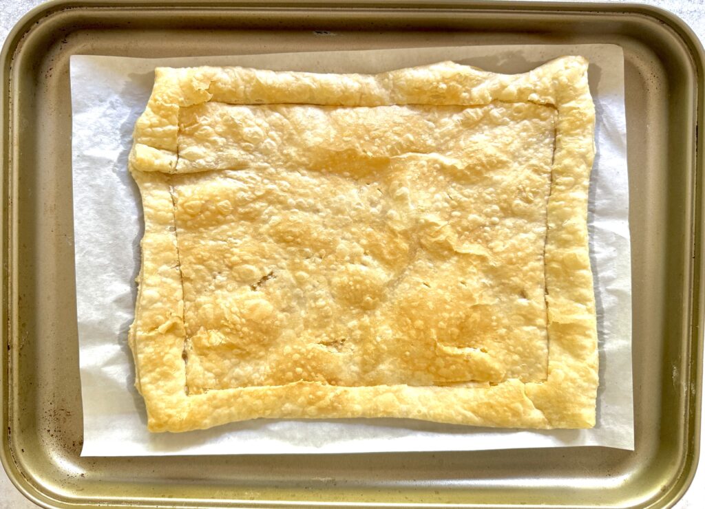 Parbaked puff pastry on a gold baking sheet